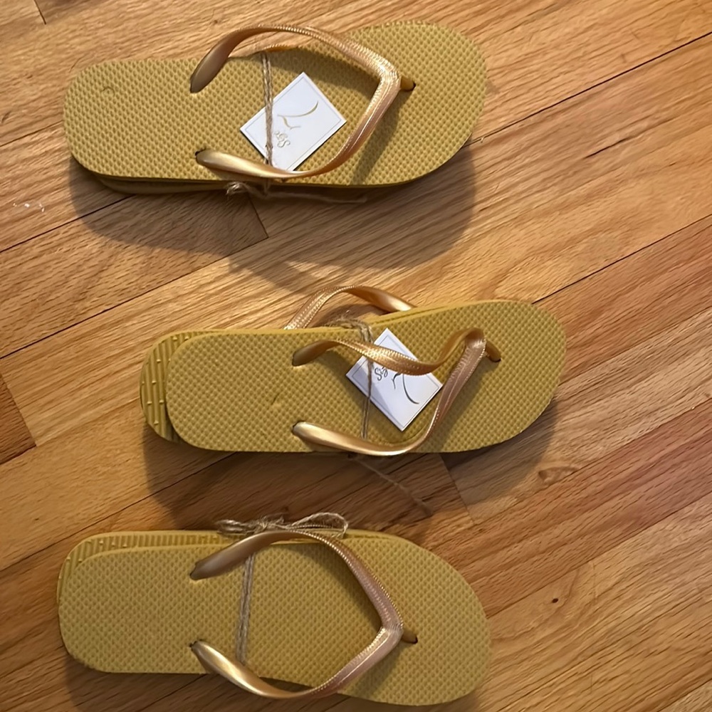 Three pair of size seven flip flops that are a rich golden tannish color